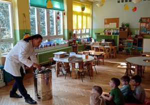 Pan Pszczelarz demonstrujący dzieciom działanie wirówki do miodu